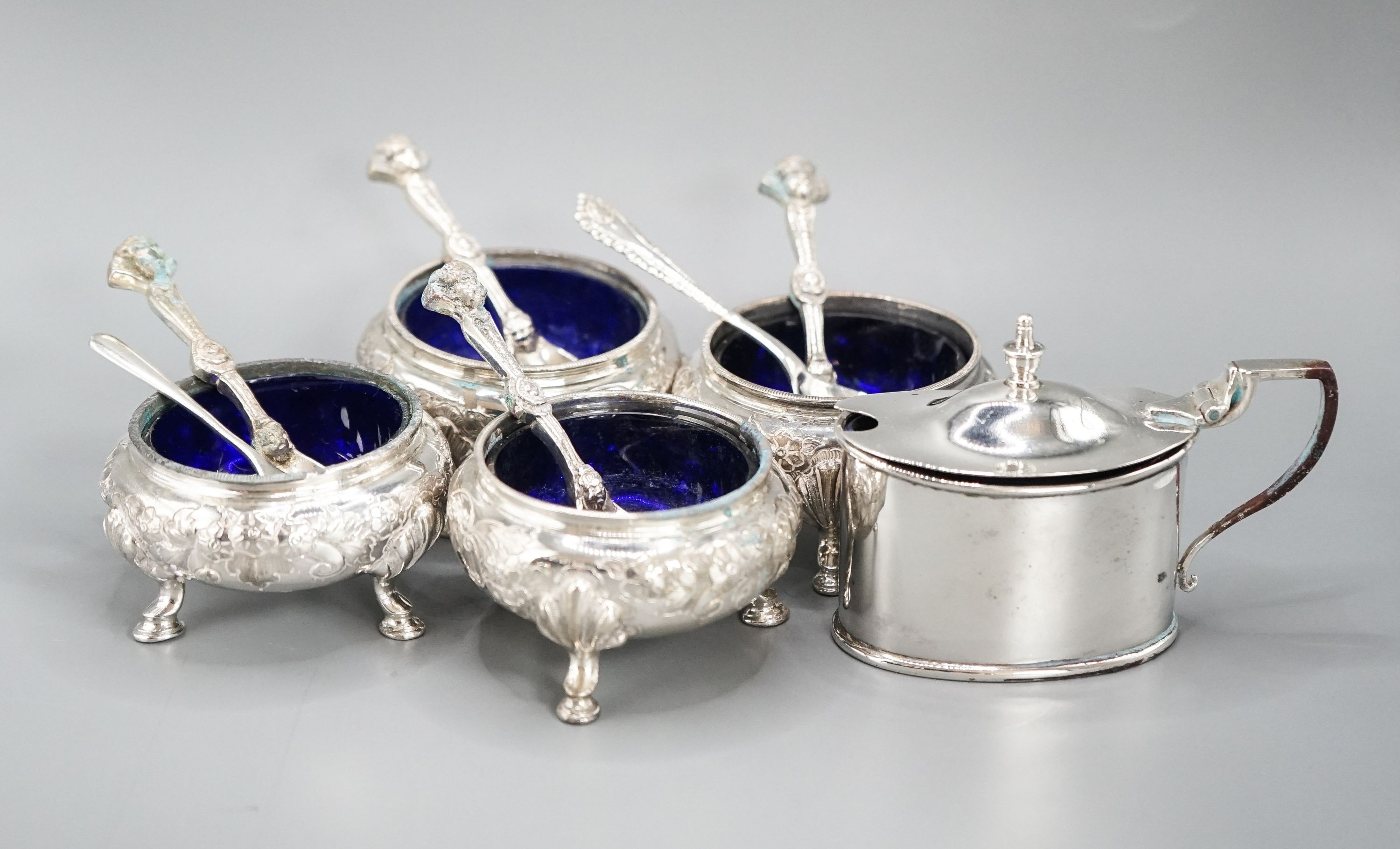 A set of four Victorian silver bun salts, Sheffield, 1869 and four associated silver spoons and a later silver mustard pot and two spoons.